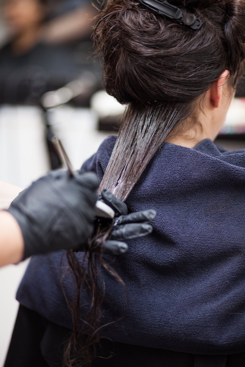 Keratin being applied to a section of dark hair at Synergy Hair Melbourne
